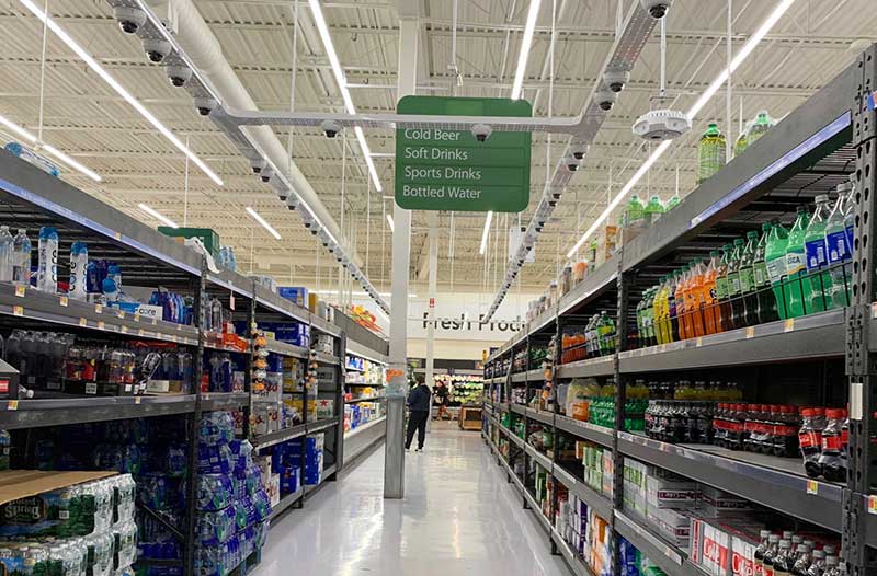  An aisle in a Walmart store with shelves with soft drinks on either side